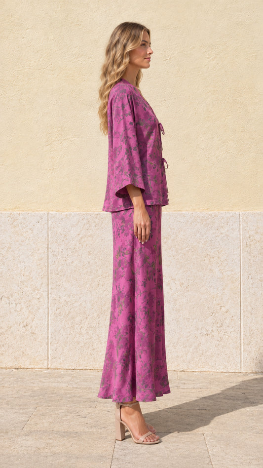Side profile view of model wearing magenta floral print two-piece skirt set