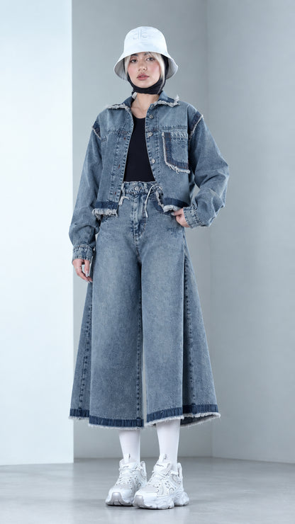 Front view of model wearing Denim Blue cropped raw hem denim jacket and matching wide leg culottes set