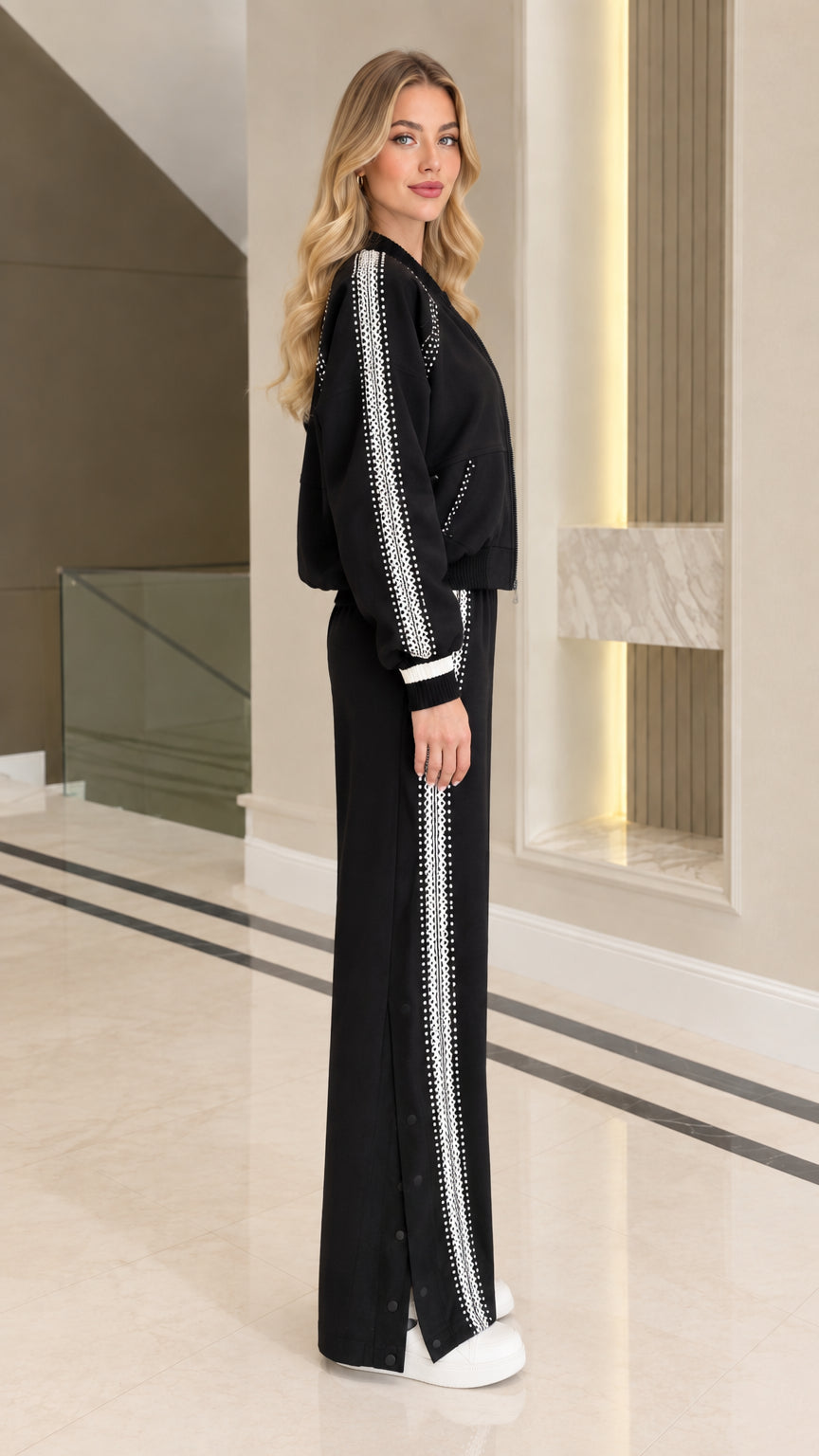 Side view of black tracksuit set showing embellished stripe on jacket sleeves and pants