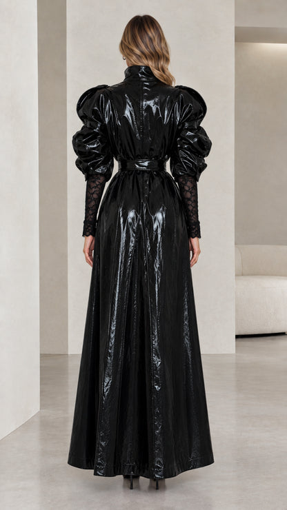 Back view of black high shine patent maxi coat showing voluminous puff sleeves and belt