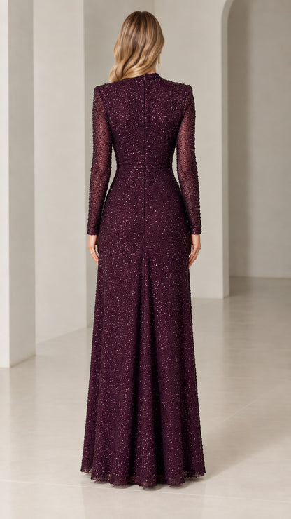 Back view of woman wearing burgundy sequined long-sleeve evening gown