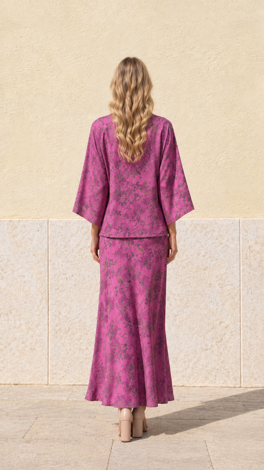 Back view of model wearing magenta floral print tie-front top and matching maxi skirt