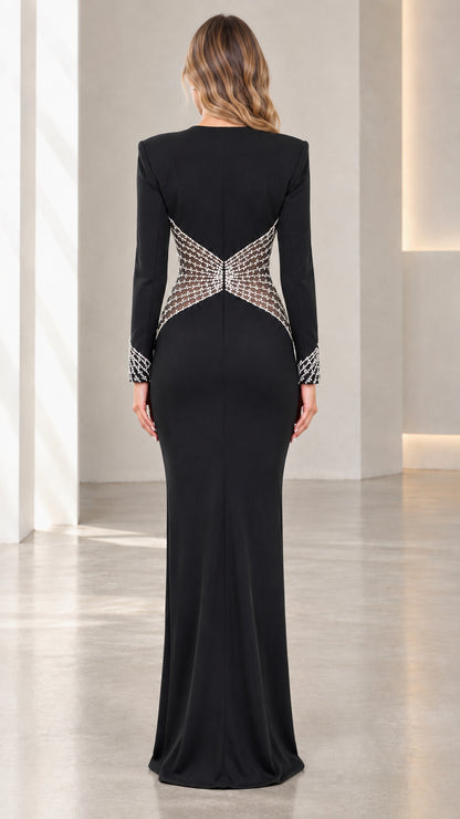 Back view of model wearing black floor-length gown featuring crystal-embellished mesh waist