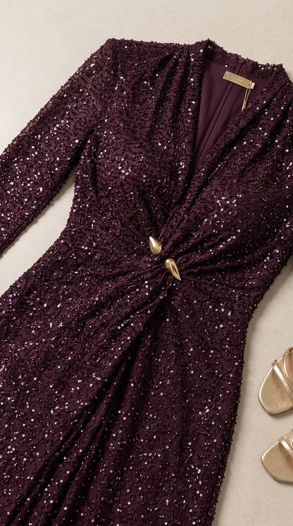 Close-up detail of burgundy sequin fabric, V-neckline, and gold waist hardware